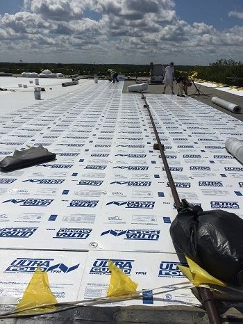Get a free quote on a new or replacement roof. Watertown Industrial roofing contractors installing a new flat roof on a manufacturing plant