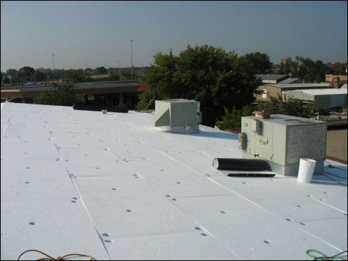 Partway through new flat roof installation Installing a new TPO membrane over a metal flat roof (mid-process) on an industrial building in Wisconsin