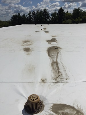 Evidence of water pooling problems and the need for commercial roofing repair